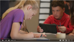 Still from the Accessible texts video series showing a female student in the foreground writing on paper and a male student in the background using an ipad.