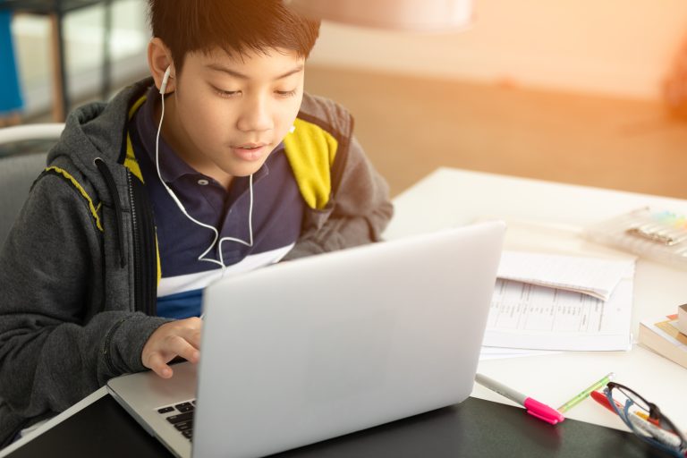 Male high school student works on laptop