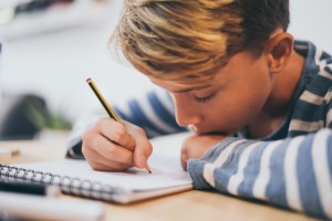 Boy writing in notebook