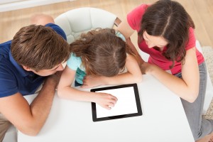 Parent and two children using a tablet