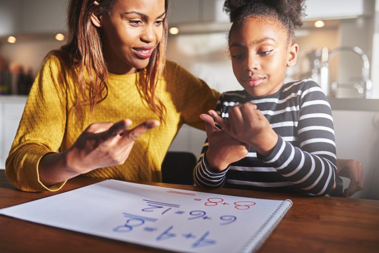 Mother and daughter learning math together, counting on their fingers.