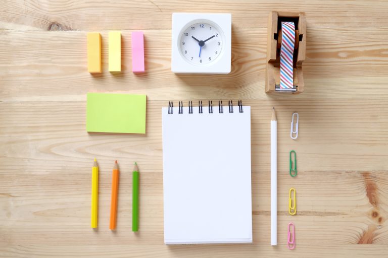 Organized desk with notebook, pens, and other office supplies