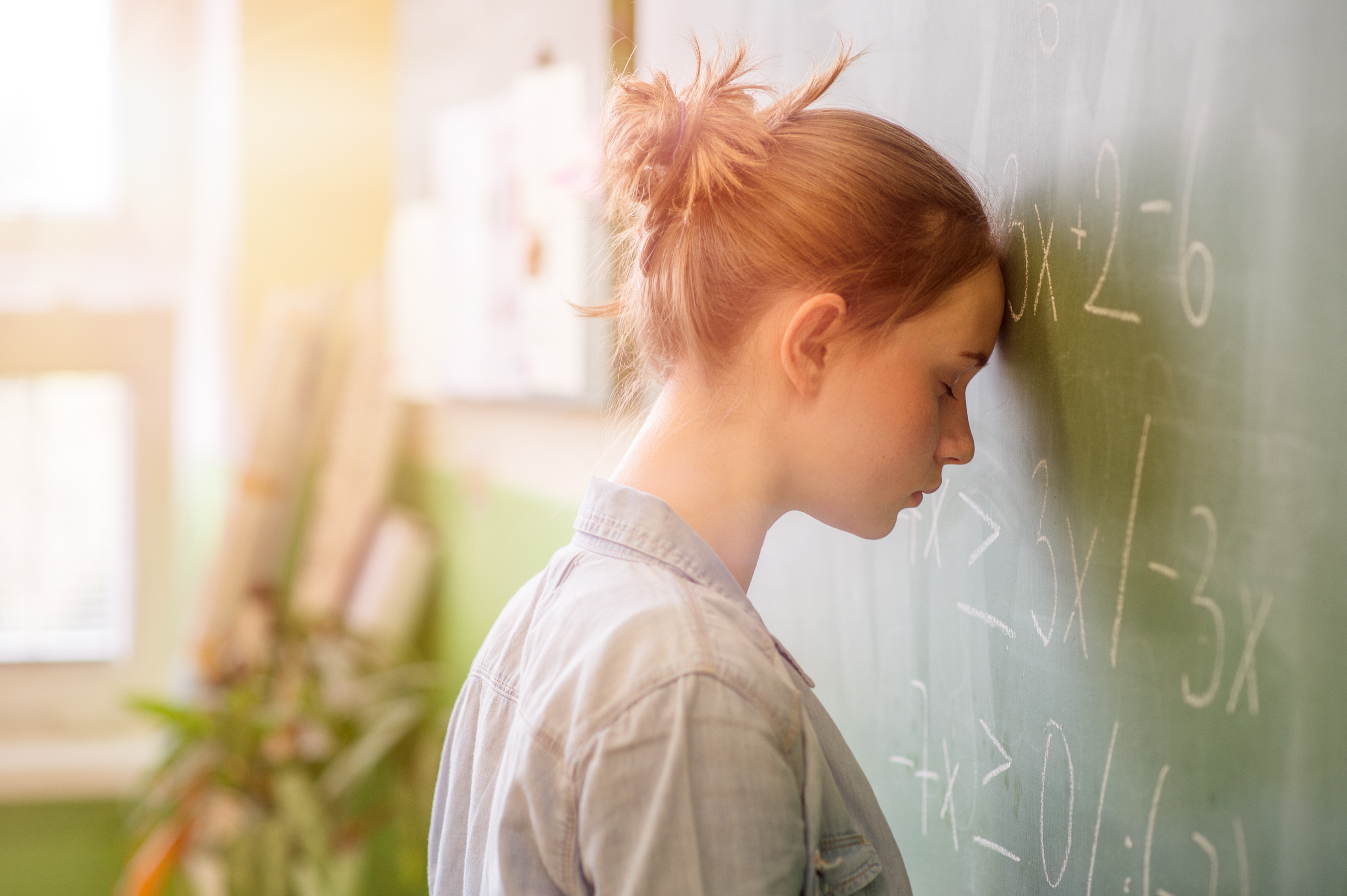 Math anxiety. Teenage girl in math class overwhelmed by the math formula.