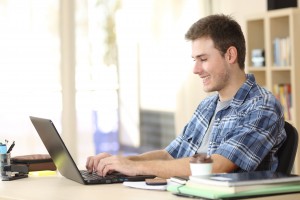 Teenage boy typing on his laptop