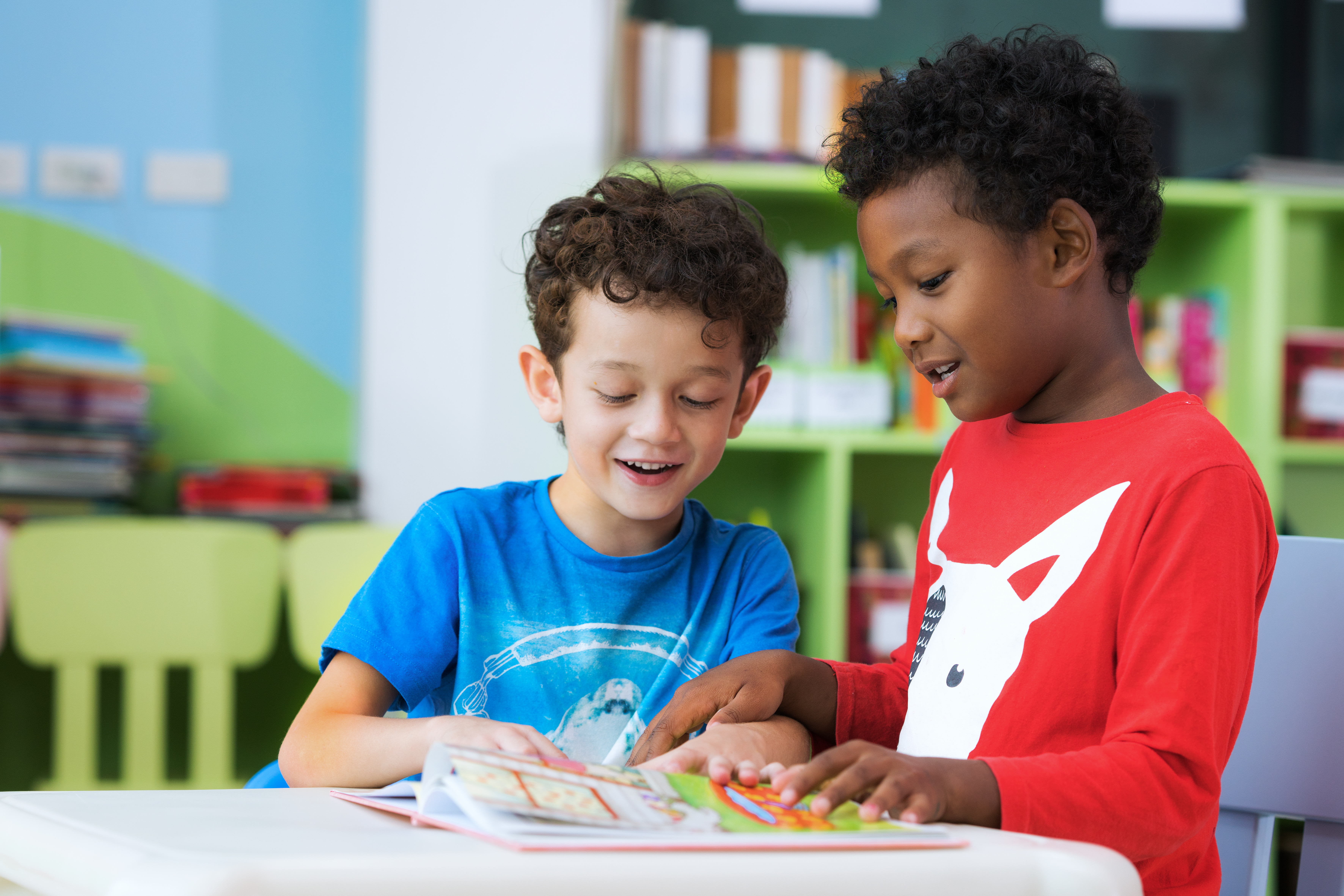 Two boys reading together in class