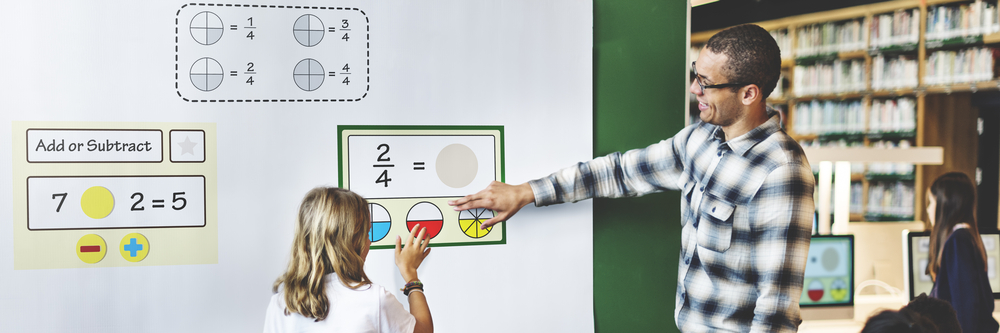 Student and teacher doing math on an interactive whiteboard