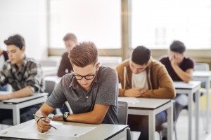 row of students at desks looking down at their work