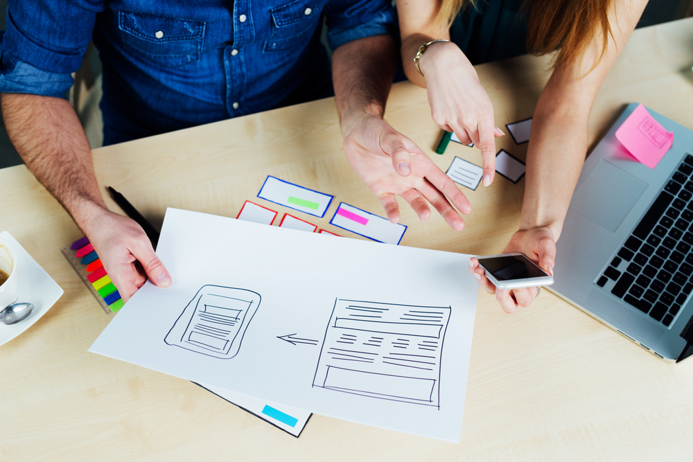 Image of 2 people brainstorming on designing a website