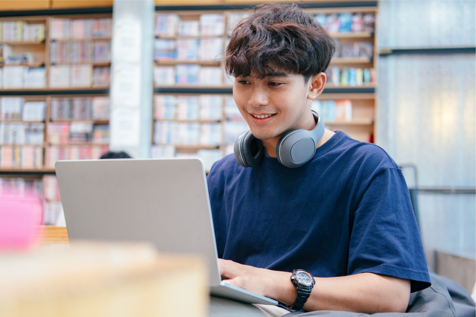 Student studying on a laptop in a library setting