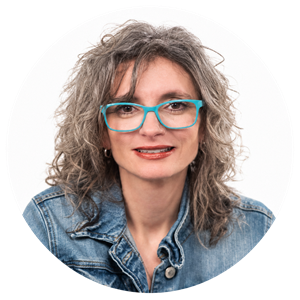 Circular headshot of Michèle Minor-Corriveau smiling at the camera, wearing turquoise glasses and a denim jacket.